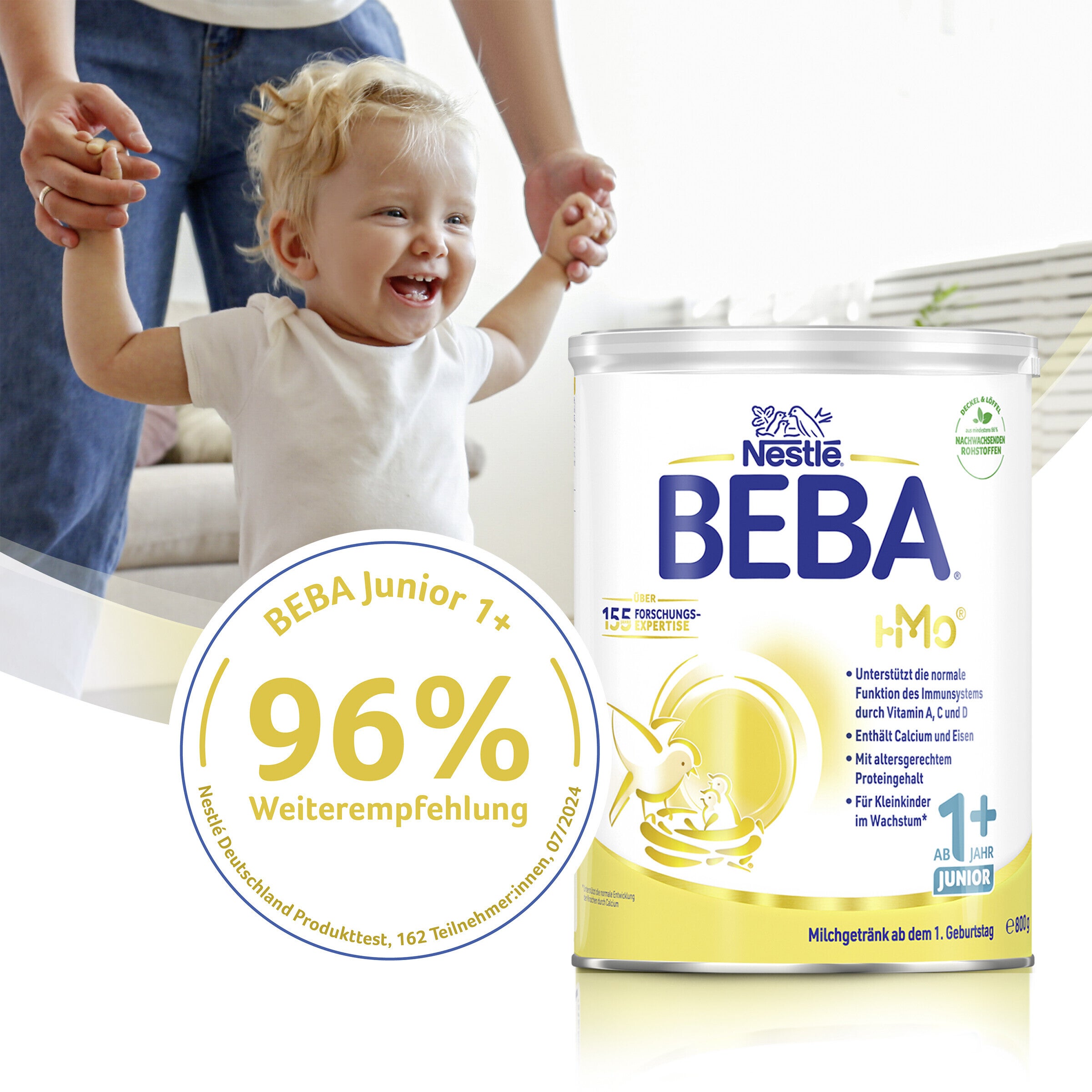 Toddler held by adult, BEBA formula container in foreground.