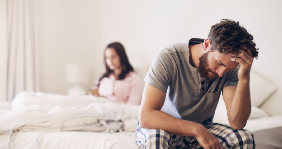 Unglücklicher Mann sitzt am Ehebett