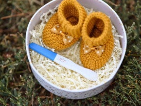 Babyschühchen mit positivem Schwangerschaftstest