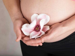 Schwangere mit Blume in den Händen