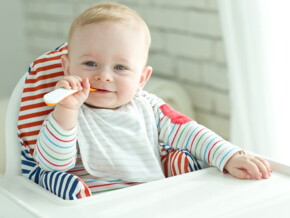 Baby zufüttern-Lachendes Baby mit Löffel Baby zufüttern-Lachendes Baby mit Löffel