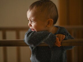 Baby schreit abends in seinem Bettchen wegen Überreizung