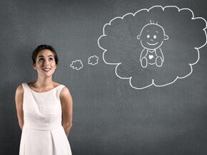 Eine Frau denkt hoffnungsvoll darüber nach, schwanger zu werden – dargestellt durch eine gezeichnete Gedankenblase mit einem Baby