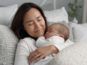 Mutter hält ihr schlafendes Neugeborenes auf dem Arm