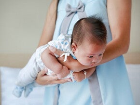 Mutter hält ihr Baby im Fliegergriff