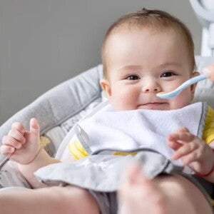 Baby zufüttern-Lachendes Baby in Babyschale