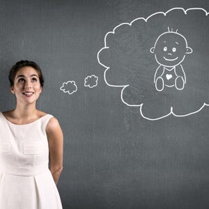 Eine Frau denkt hoffnungsvoll darüber nach, schwanger zu werden – dargestellt durch eine gezeichnete Gedankenblase mit einem Baby