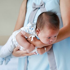 Mutter hält ihr Baby im Fliegergriff Mutter hält ihr Baby im Fliegergriff
