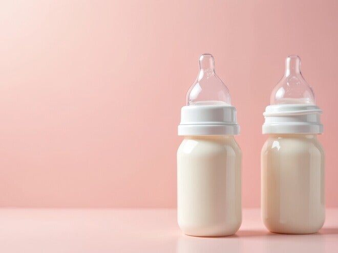 Zwei beieinander stehende und mit Milch gefüllte Babyflaschen.