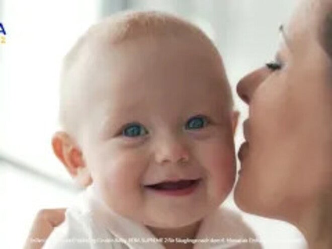 Mutter küsst Baby auf die Wange, Babygesicht unkenntlich