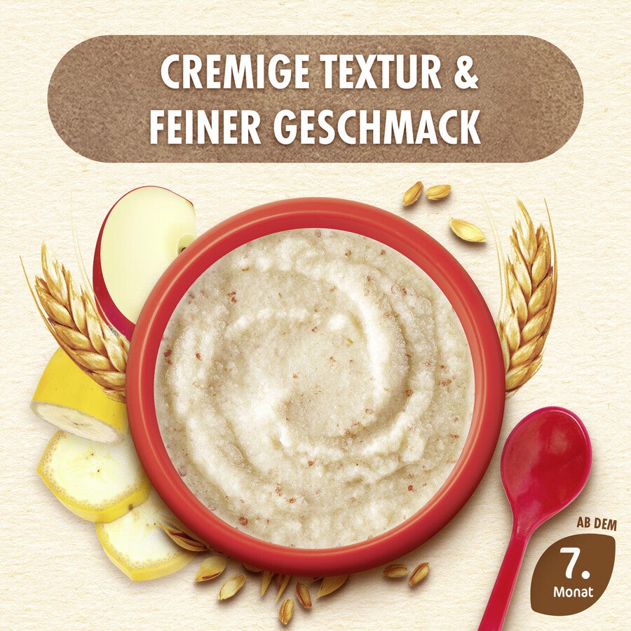 Bowl of creamy porridge with bananas and wheat, red spoon beside.