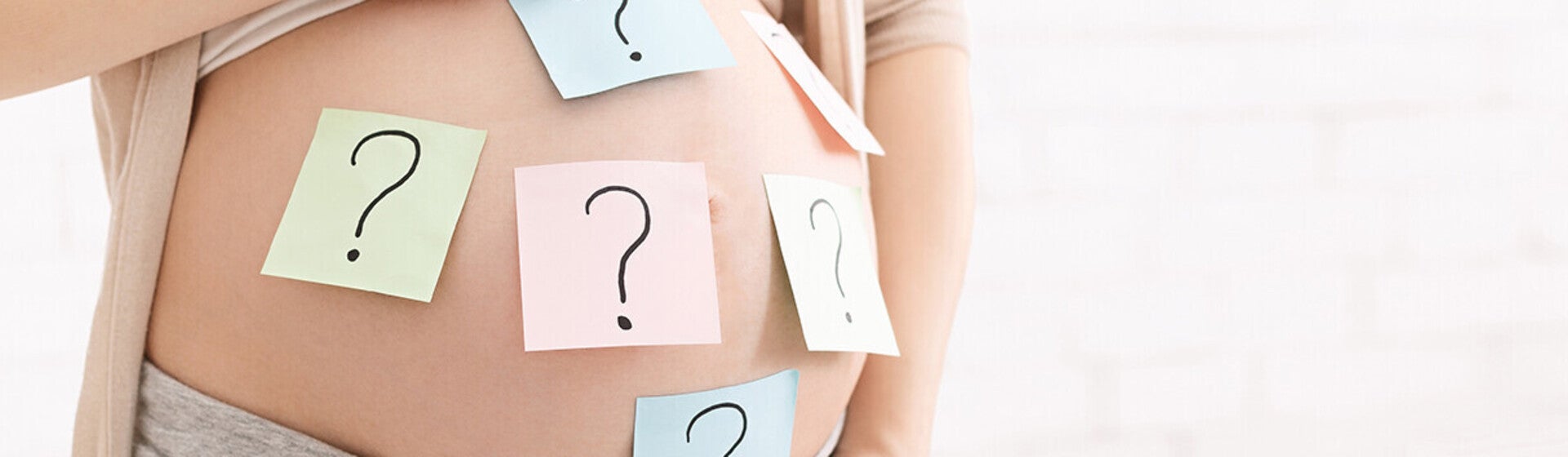 hochschwangere_frau_mit_offenem_bauch_und_vielen_post-it_s_mit_fragezeichen_drauf.jpg