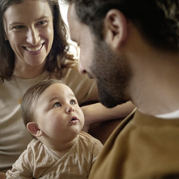 Eltern schauen auf ihr Baby und lächeln