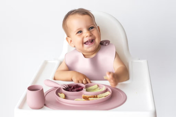 Baby zufüttern- Baby im Hochstuhl vor seinem Essen Baby zufüttern- Baby im Hochstuhl vor seinem Essen