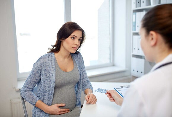 schwangere Frau sitzt bei ihrer Ärztin im Patientenzimmer schwangere Frau sitzt bei ihrer Ärztin im Patientenzimmer
