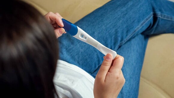 Positiver Schwangerschaftstest, der den Beginn der Hebammen-Suche markiert. 