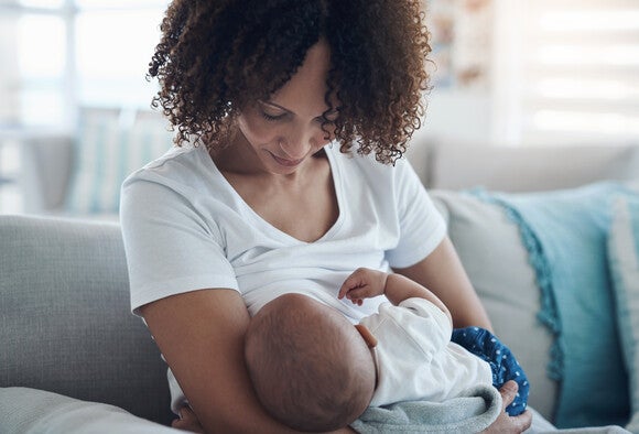 Mutter stillt ihr Baby friedlich auf dem Arm