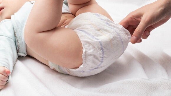 Mutter prüft, ob Babywindel voll ist Mutter prüft, ob Babywindel voll ist