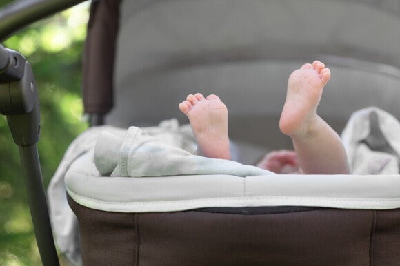 Babyfüßchen schauen aus dem Kinderwagen raus Babyfüßchen schauen aus dem Kinderwagen raus