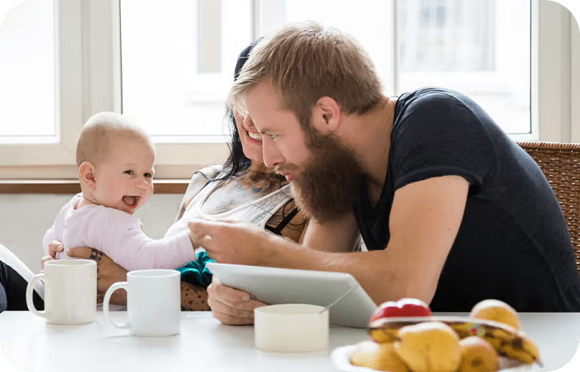 Mutter Vater Kind lachen am Tisch | Babyservice Mutter Vater Kind lachen am Tisch | Babyservice
