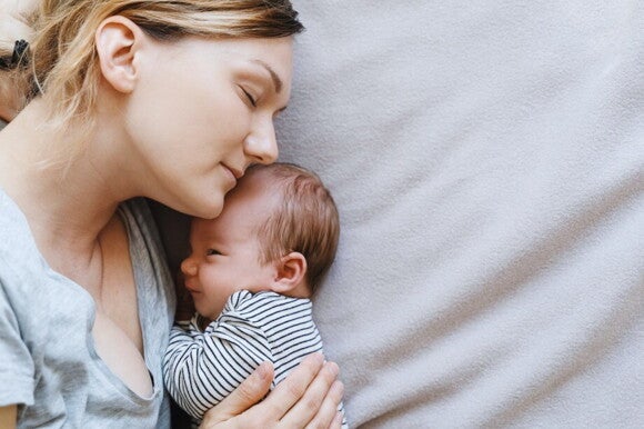 Mutter hält ihr neugeborenes Kaiserschnitt-Baby in den Armen