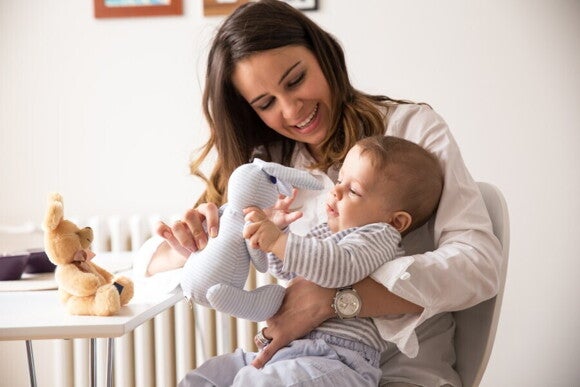 Mutter kuschelt und spielt abends mit ihrem Baby