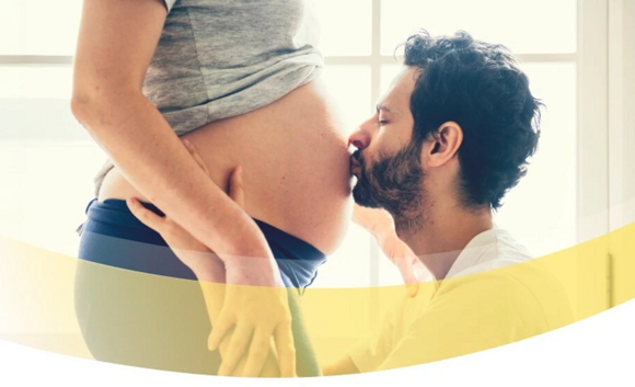 Schwangerschaftskalender - Mann küsst Frau auf Babybauch
