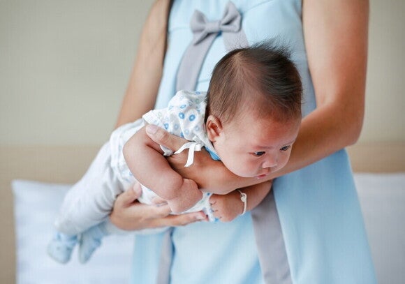 Mutter hält ihr Baby im Fliegergriff