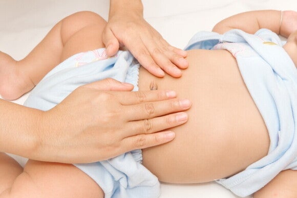 Mutter massiert den Bauch ihres Babys