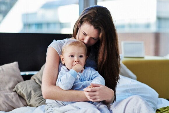 Eine Mutter hält ihr Baby im Arm und zeigt die liebevolle Verbundenheit der beiden. Eine Mutter hält ihr Baby im Arm und zeigt die liebevolle Verbundenheit der beiden.