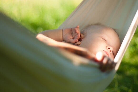 Schlafendes Baby in einer Hängematte im freien.