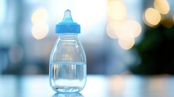 Halbvolle Babyflasche gefüllt mit Wasser