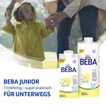 Beba Junior milk cartons in foreground, child holding hands in blurred background.